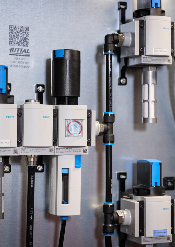 Detailaufnahme von Schalttafeln und Schaltschränken mit integrierten Festo-Komponenten und Verkabelungssystemen in einem Industrie Bereich. Die Elektro Arbeiten umfassen Mittel- und Hochspannungsanlagen sowie Glasfaserarbeiten, die für Anwendungen in Erneuerbaren Energien optimiert sind.