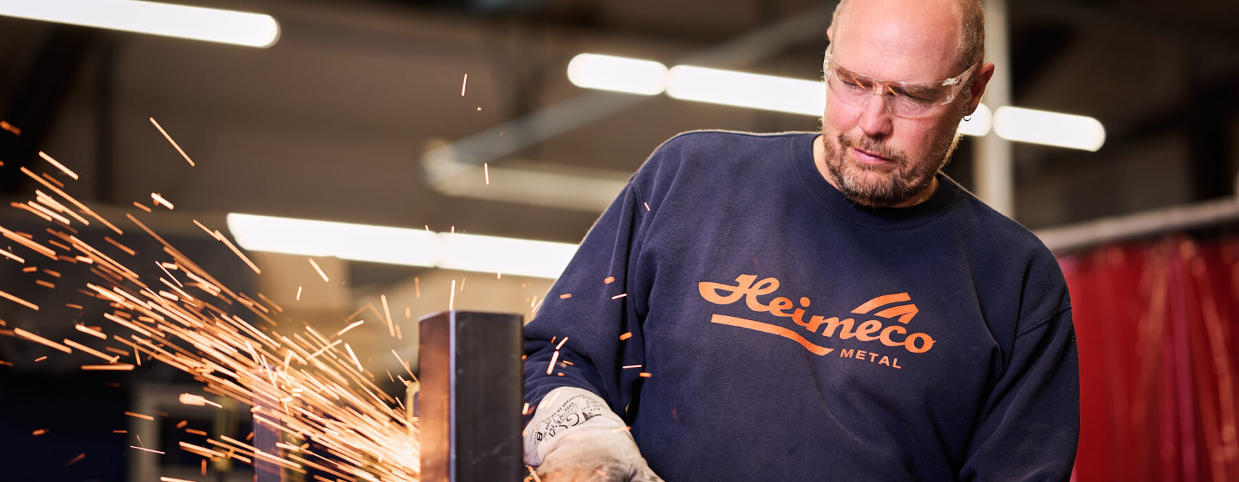 Metallbauer bei der präzisen Blechverarbeitung mit Winkelschleifer in der Metallbau-Fertigung