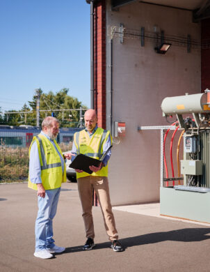 Techniker besprechen Planung eines Infrabel Gleichrichterunterwerks mit Transformator-Gleichrichter-Gruppen