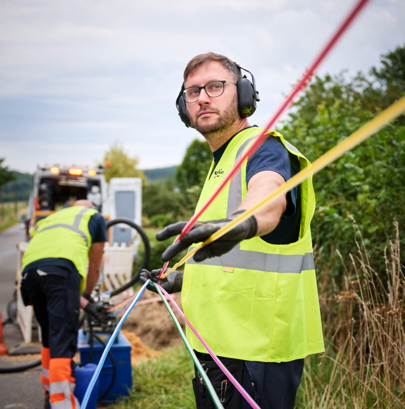 Techniker ziehen farbige Kabel für Mittelspannungsanlagen und Niederspannungsverteilung im Freien