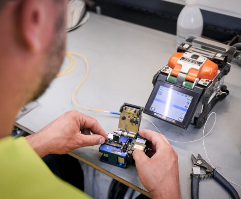 Techniker bedient Fusionsspleißmaschine für Stromnetzinfrastruktur und Mittelspannungsanlagen